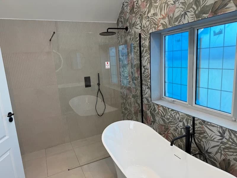 Clean white bathroom with chrome fixtures and marble tiling